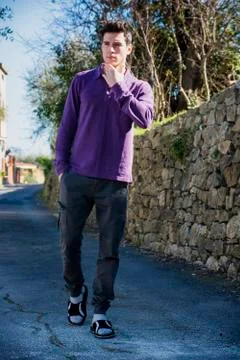Handsome young man walking along rural road Stock Photos