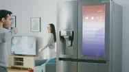 Handsome Young Man Walks Over To Refrigerator While Drinking His Morning Coffee Stock Footage