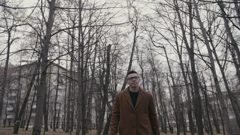 Handsome young man in warm coat walking on street during autumn weather Stock Footage 156612751