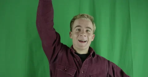 Handsome young man waves to an old friend on a greenscreen Vidéo 59725537