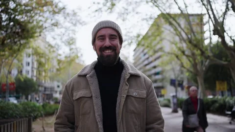 Handsome young man in winter clothes and walking outdoors looking camera Stock Footage 261341776
