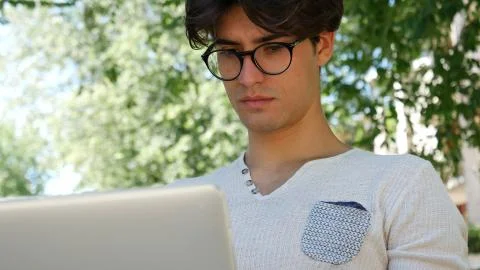 Handsome young man working at computer in park Stock Photos