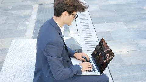 Handsome young man working at computer outdoor Stock Photos