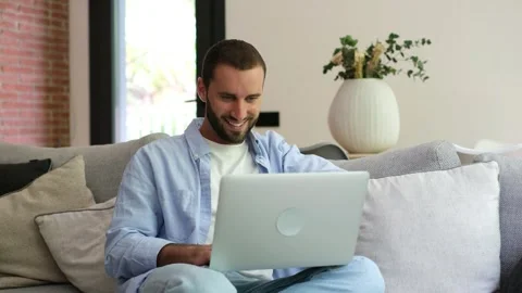 Handsome young man working on laptop at home Stock Footage 335588544