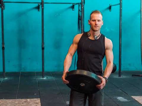 Handsome young man working out in gym Stock Photos