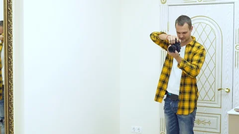 Handsome young man in a yellow checkered shirt, professional photographer Vidéo 119599161