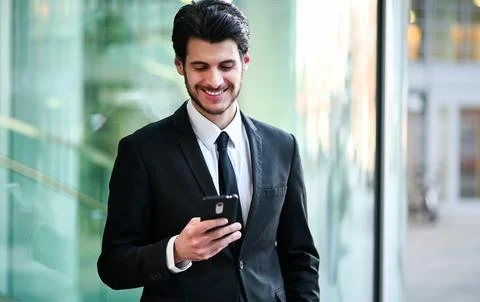 Handsome young manager using a smartphone outdoor Fotos Stock