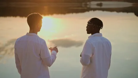 Handsome young men spend sunset at the beach, vaping and drinking 스톡 동영상 197171045