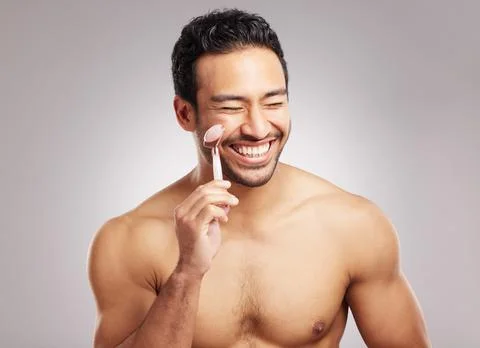 Handsome young mixed race man posing shirtless in studio isolated against a grey Stock Photos