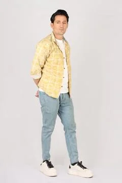 A handsome young pakistani man posing in printed yellow shirt Stock Photos
