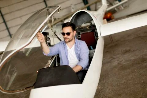 Handsome young pilot checking his ultralight airplane before flight Stock Photos