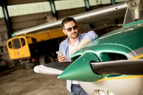 Handsome young pilot checking his ultralight airplane before flight Stock Photos