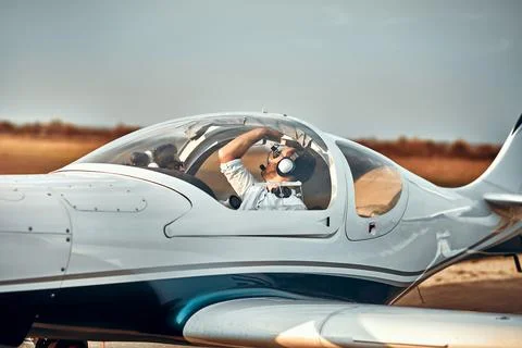 Handsome young pilot checking his ultralight airplane before flight Stock Photos