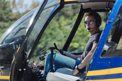 Handsome young pilot posing inside helicopter Stock Photos