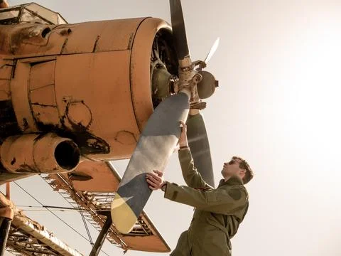 A handsome young pilot standing next to the propeller Stock Photos