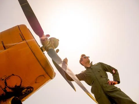 A handsome young pilot standing next to the propeller Stock Photos