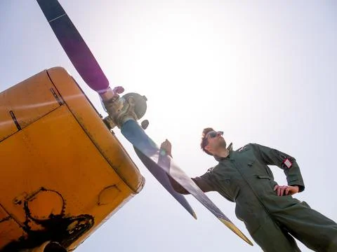 A handsome young pilot standing next to the propeller Stock Photos