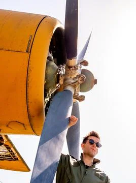 A handsome young pilot standing next to the propeller Stock Photos