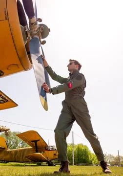 A handsome young pilot standing next to the propeller Stock Photos