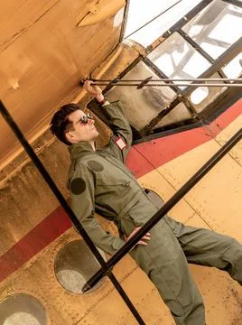 A handsome young pilot standing on the wing of a plane Stock Photos