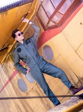 A handsome young pilot standing on the wing of a plane Stock Photos
