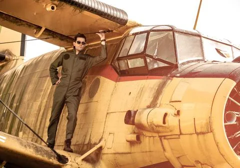 A handsome young pilot standing on the wing of a plane Stock Photos