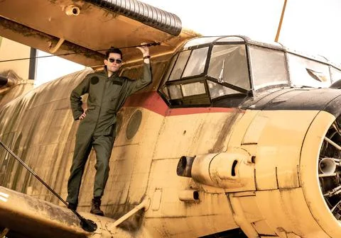 A handsome young pilot standing on the wing of a plane Stock Photos