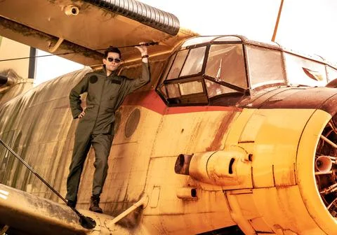 A handsome young pilot standing on the wing of a plane Stock Photos