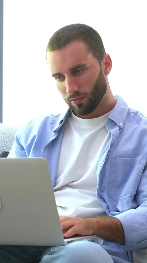 Handsome young professional working remotely on a project, sitting comfortably Stock Footage 345079470
