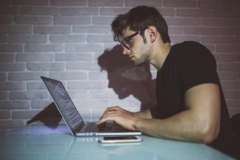 Handsome young programmer working at home late in evening Stock Photos
