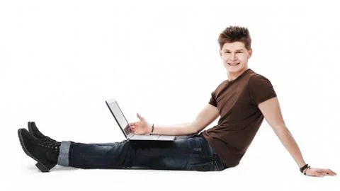 Handsome young relaxing man using laptop and lying on the sofa Stock Photos