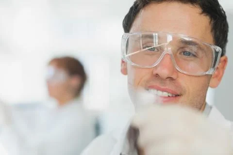 Handsome young scientist looking at microscope slide 写真素材