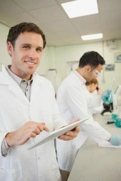 Handsome young scientist using his tablet while standing in the laboratory Photos