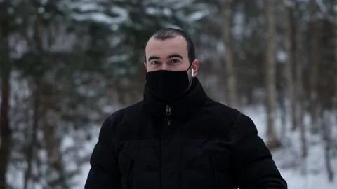 Handsome young southerner in outerwear, a mask, an earpiece and looking around Stock Footage 146447986
