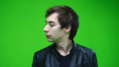 Handsome of the young white man in jacket looking sideways over green screen Vídeos de archivo 144381371