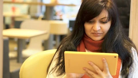 Handsome young woman using tablet and drinking coffee in a restaurant. Stock Footage 83761824