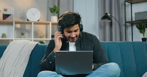 Handsone cheerful funny young bearded guy in headphones sitting in relaxed pose Stock Footage 150155927