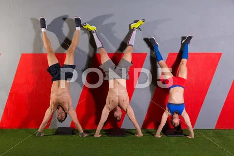 Handstand push-up group workout at gym Stock Photos