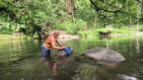 Handwashing the clothes in the river Stock Footage 278510096