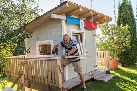 Handwerker baut sich selbst eine stabile Holzhütte im Garten Heimwerker ba.. Stock Photos