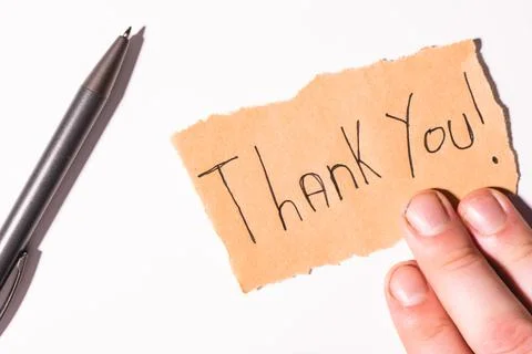 A handwriting  Thank you note on brown paper, on a white background Stock Photos