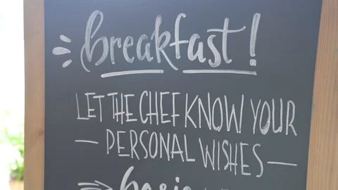 Handwritten breakfast menu on blackboard. Tilt down and hand held Stock-Footage 86062803