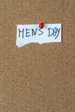 Handwritten message on paper notes 'MEN'S DAY' pinned on cork board signifies Foto stock