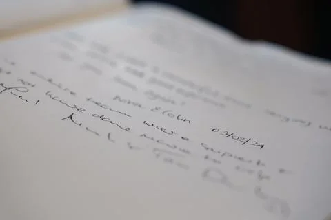 Handwritten note D30 or 12 or 21 in cursive on white paper, indoors Fotos de archivo