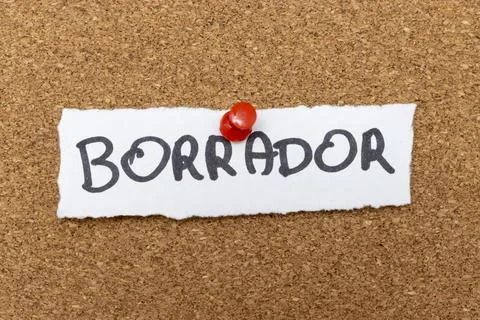Handwritten note displaying the word BORRADOR pinned to a corkboard. This term Stock Photos