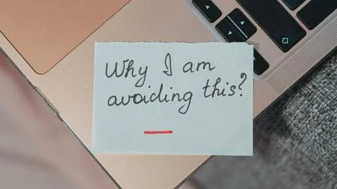 Handwritten note on laptop asking why avoidance is occurring Stock Photos