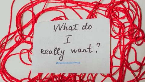 Handwritten note on paper surrounded by tangled red thread Stock Photos
