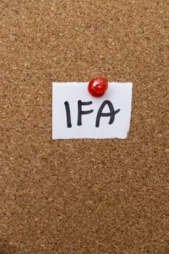 Handwritten note reading IFA pinned to a corkboard. IFA can refer to various Stock Photos