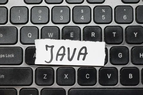 Handwritten note reading JAVA placed on a black computer keyboard. Java is a Stockfoto's