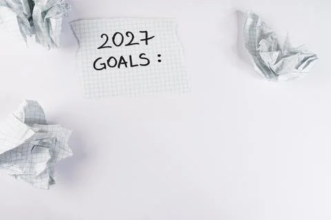 Handwritten note with the text 2027 goals placed on a surface surrounded by.. 스톡 사진